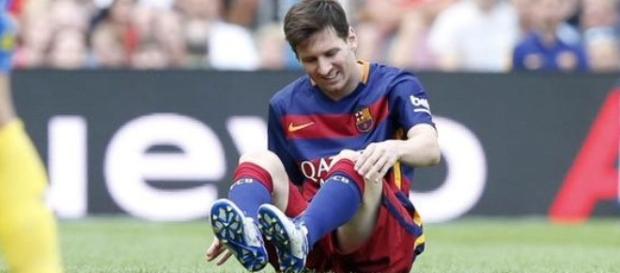 Lionel Messi attending to leg during a game Lionel Messi attending to leg during a game