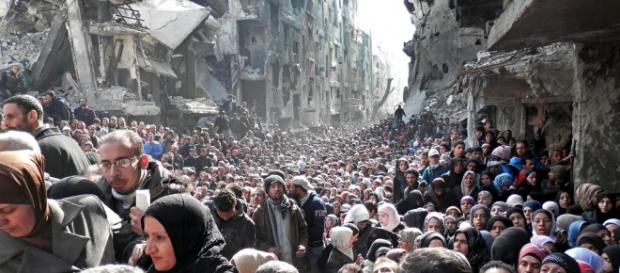Von Krieg bedrohte Menschen in Syrien vor Ruinen Von Krieg bedrohte Menschen in Syrien vor Ruinen