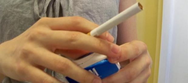Chica joven con paquete de tabaco y cigarro Chica joven con paquete de tabaco y cigarro