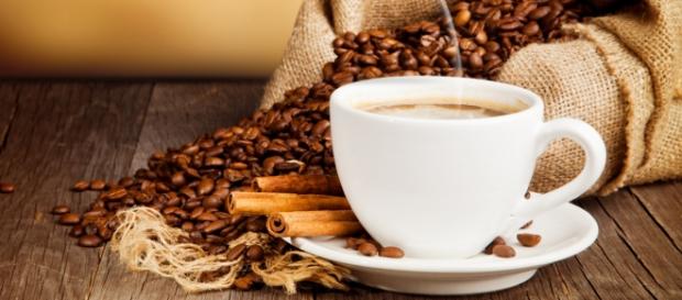 coffe beans, a cup of coffee and cinnamon rolls coffe beans, a cup of coffee and cinnamon rolls