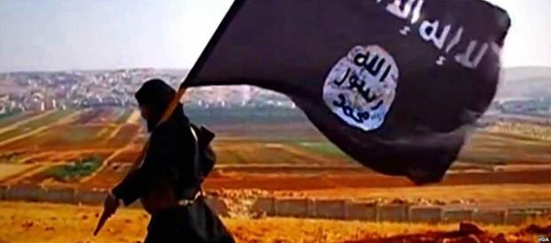 Militante del Daesh portando su bandera Militante del Daesh portando su bandera