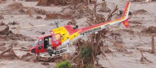 Helicóptero sobrevoando a área atingida pela lama Helicóptero sobrevoando a área atingida pela lama