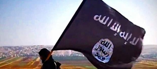 Militante de Daesh portando la bandera Militante de Daesh portando la bandera