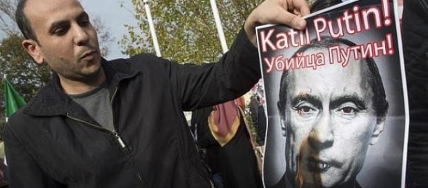 Un hombre quema la imagen de Putin en una protesta Un hombre quema la imagen de Putin en una protesta