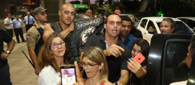 Skinhead próximo a policial e filho de Bolsonaro. Skinhead próximo a policial e filho de Bolsonaro.