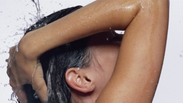 Una donna mentre si fa lo shampoo