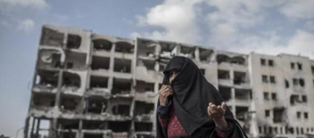 Edificio y mujer desolados por los ataques Edificio y mujer desolados por los ataques
