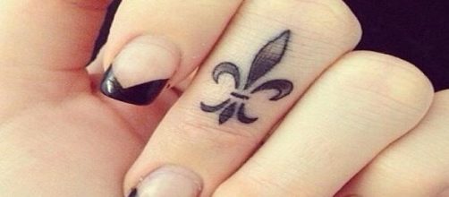 Tatuagem de flor-de-lis no dedo
