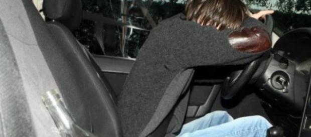 Uomo ubriaco al volante con bottiglia Uomo ubriaco al volante con bottiglia
