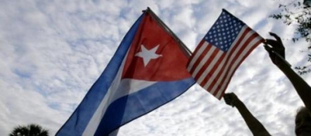 Old lady holding Cuba and US flags. Old lady holding Cuba and US flags.