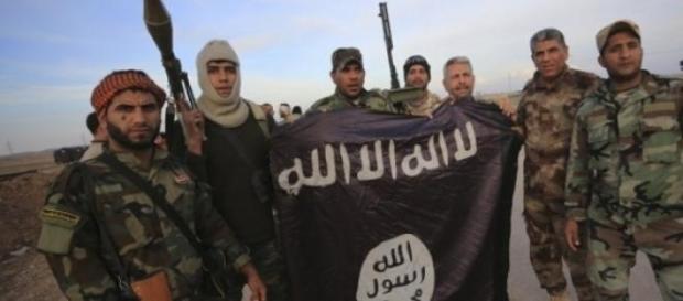 Militantes do EI exibem a bandeira do grupo Militantes do EI exibem a bandeira do grupo