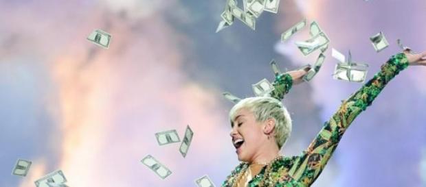 Miley Cyrus a atirar notas em concerto Miley Cyrus a atirar notas em concerto