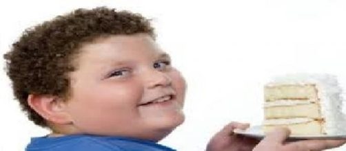 Bambino obeso che mangia una torta