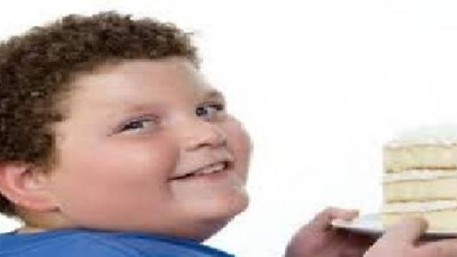 Bambino obeso che mangia una torta