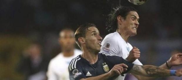 Lucas Biglia luchando el balón con Cavani Lucas Biglia luchando el balón con Cavani