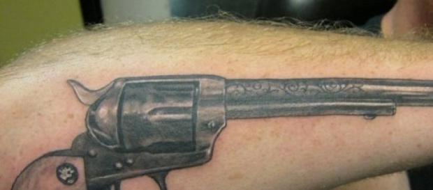 Un pistolar îşi etalează tatuajul de pe antebraţ Un pistolar îşi etalează tatuajul de pe antebraţ
