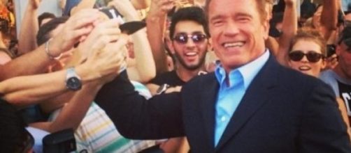 Arnold Schwarzenegger saluta i fans