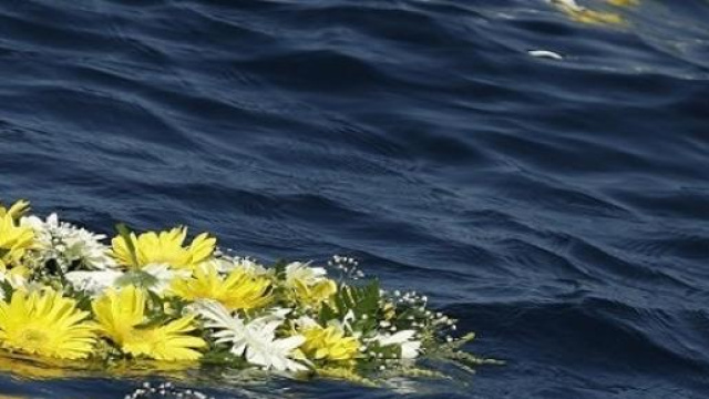Corona di fiori per i migranti morti in mare.