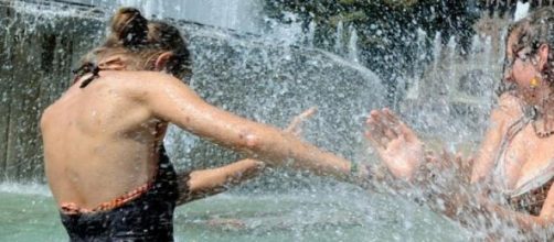 Due ragazze scherzano in fontana