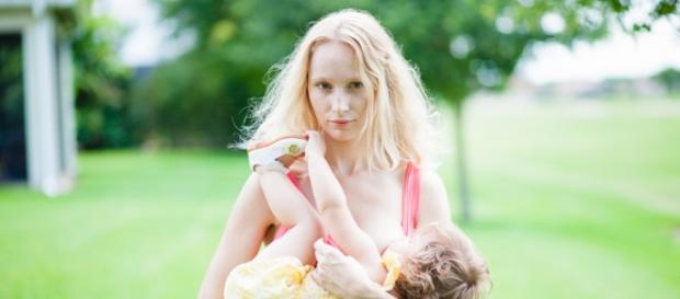 Mom while breastfeeding her child in public. Mom while breastfeeding her child in public.