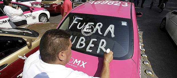 Manifestante pincha carro do Uber no México Manifestante pincha carro do Uber no México
