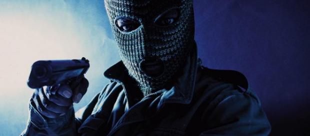 Un rapinatore armato di pistola Un rapinatore armato di pistola