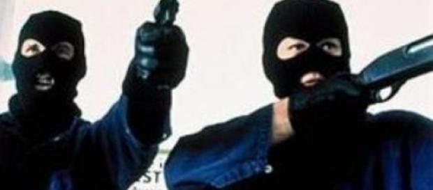 a volto coperto e con un'arma in mano a volto coperto e con un'arma in mano