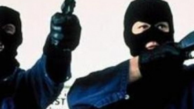 a volto coperto e con un'arma in mano