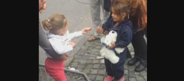Niña alemana dando caramelos a refugiada siria Niña alemana dando caramelos a refugiada siria