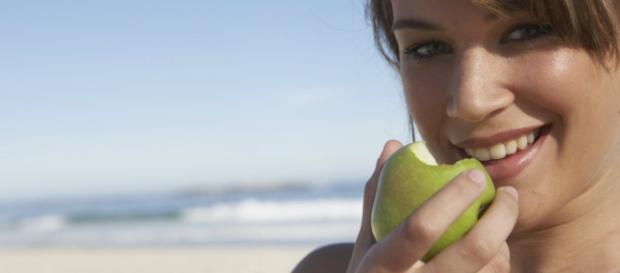 Mujer comiendo una manzana verde Mujer comiendo una manzana verde