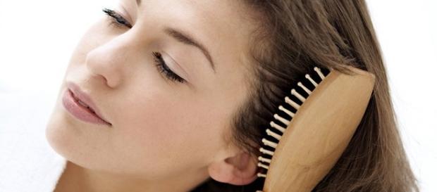 una chica cepillandose el cabello una chica cepillandose el cabello