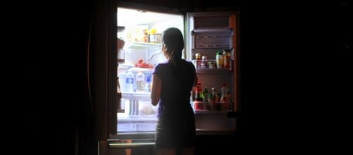 Donna dinanzi al frigo di notte