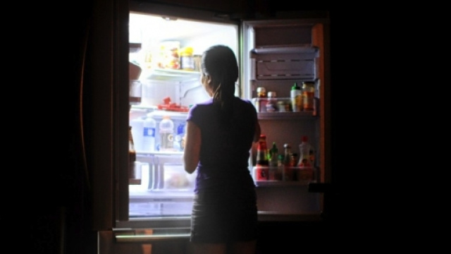 Donna dinanzi al frigo di notte