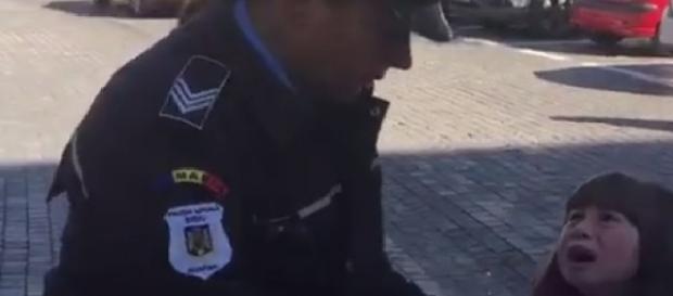 Polițista ține fetița strâns de braț Polițista ține fetița strâns de braț