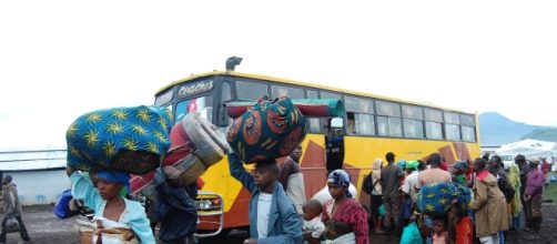 Migranti in attesa di salire su un bus