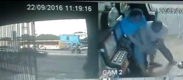 Em uma das cenas gravadas no vídeo é possível ver o policial de camisa azul lutando contra dois homens Em uma das cenas gravadas no vídeo é possível ver o policial de camisa azul lutando contra dois homens