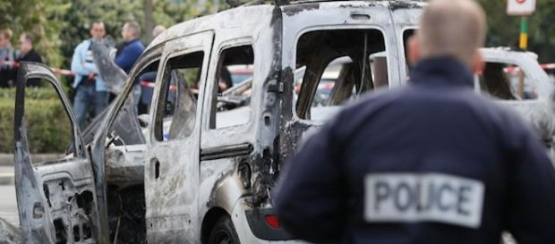l'express.fr Un policier devant l'une des carcasses incendiées l'express.fr Un policier devant l'une des carcasses incendiées