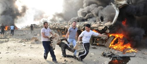 May 10, 2012: People run carrying a burnt body at the site of an explosion in Damascus