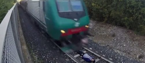 Yes, that is a person lying on the tracks waiting for a speeding train to pass over them in a deadly dare trend. Blasting News Library- mirror.co.uk