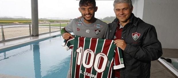 Das mãos de Peter Siemsen, Gustavo Scarpa recebe camisa alusiva aos 100 jogos pelo Fluminense. (Foto: Nelson Perez/Divulgação FFC) Das mãos de Peter Siemsen, Gustavo Scarpa recebe camisa alusiva aos 100 jogos pelo Fluminense. (Foto: Nelson Perez/Divulgação FFC)