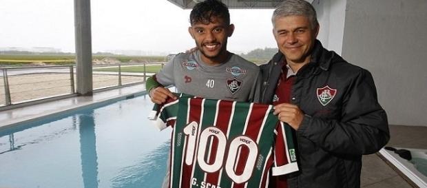 Ao lado do presidente Peter Siemsen, Gustavo Scarpa recebendo camisa alusiva ao número de jogos pelo Fluminense (Foto: Arquivo) Ao lado do presidente Peter Siemsen, Gustavo Scarpa recebendo camisa alusiva ao número de jogos pelo Fluminense (Foto: Arquivo)