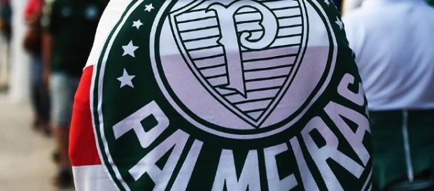 Torcedor do Palmeiras caminha com bandeira nas costas. Torcedor do Palmeiras caminha com bandeira nas costas.