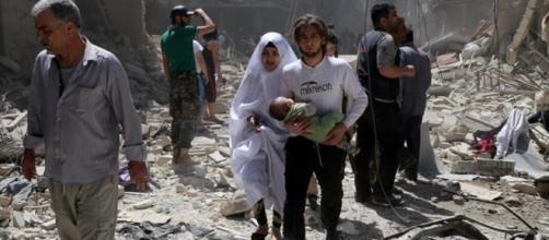 Habitantes de Aleppo caminan en medio de los escombros