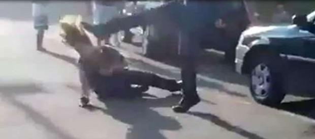 Na imagem a segurança já caída em quanto o homem a atinge com um chute no rosto. Na imagem a segurança já caída em quanto o homem a atinge com um chute no rosto.