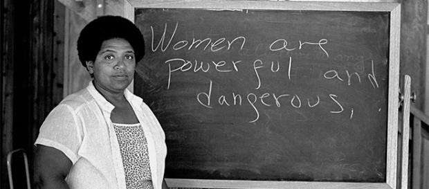 Audre Lorde junto a una pizarra que dice: "las mujeres somos poderosas y peligrosas" Audre Lorde junto a una pizarra que dice: "las mujeres somos poderosas y peligrosas"