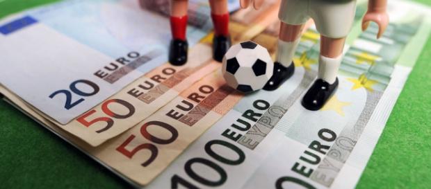 Pelota de fútbol de juguete encima de billetes Pelota de fútbol de juguete encima de billetes