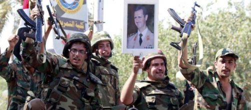 Militari siriani espongono l'immagine di Assad