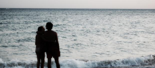 Una pareja abrazada contempla el mar. Una pareja abrazada contempla el mar.