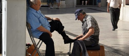 Un lustrascarpe mentre è intento nel suo lavoro