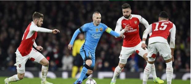 Iniesta manejando el balón rodeado de tres rivales Iniesta manejando el balón rodeado de tres rivales